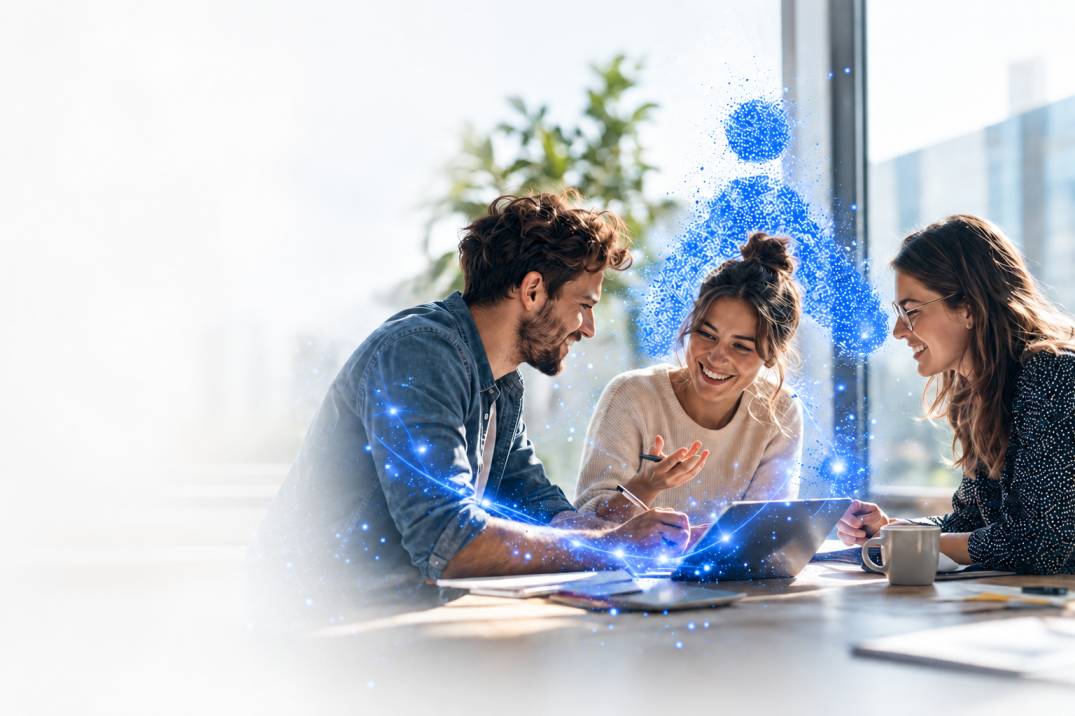 Three coworkers collaborating around a laptop at a sunny table, with blue digital connectivity visuals around them