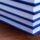 Stack of blue-bound hardcover books stacked on a wooden table surface.